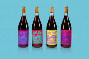 Four bottles of 2022 Hillside Vineyard 'Lune Juice' Zinfandel on blue background